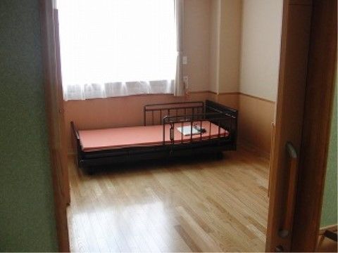 居室には柵付きのベッドが用意されている。高さが低めなので、使いやすく、入居者様は安全に寝起きすることができる。
