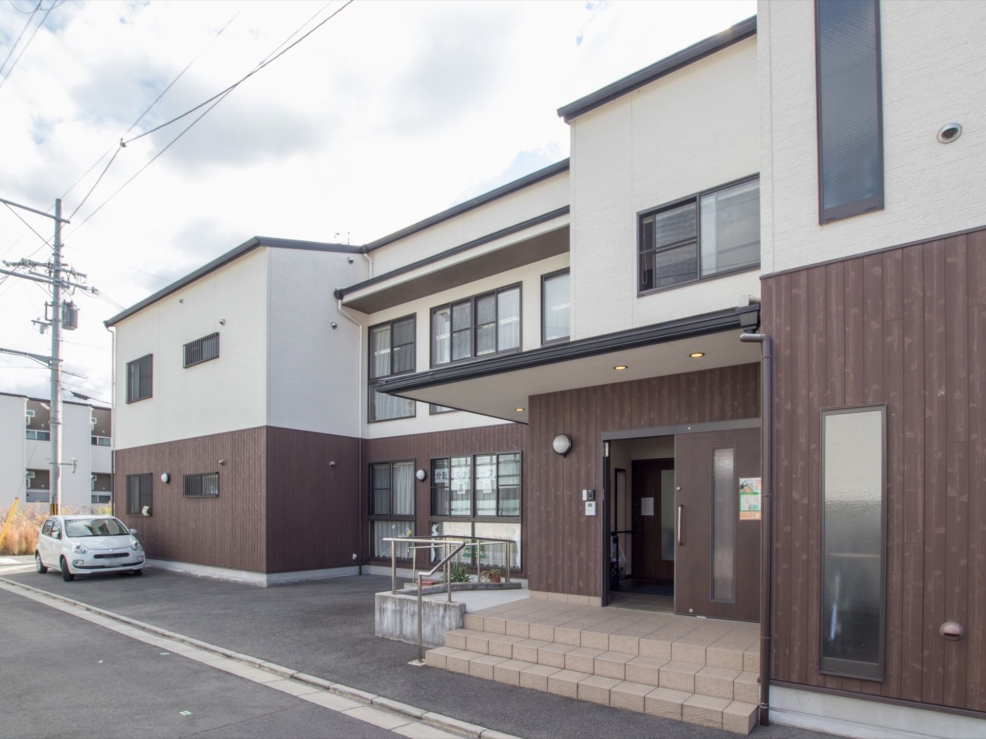 出入口には階段とスロープを設置している。入居者様の身体の状況により、どちらかを選択して通行することができる。