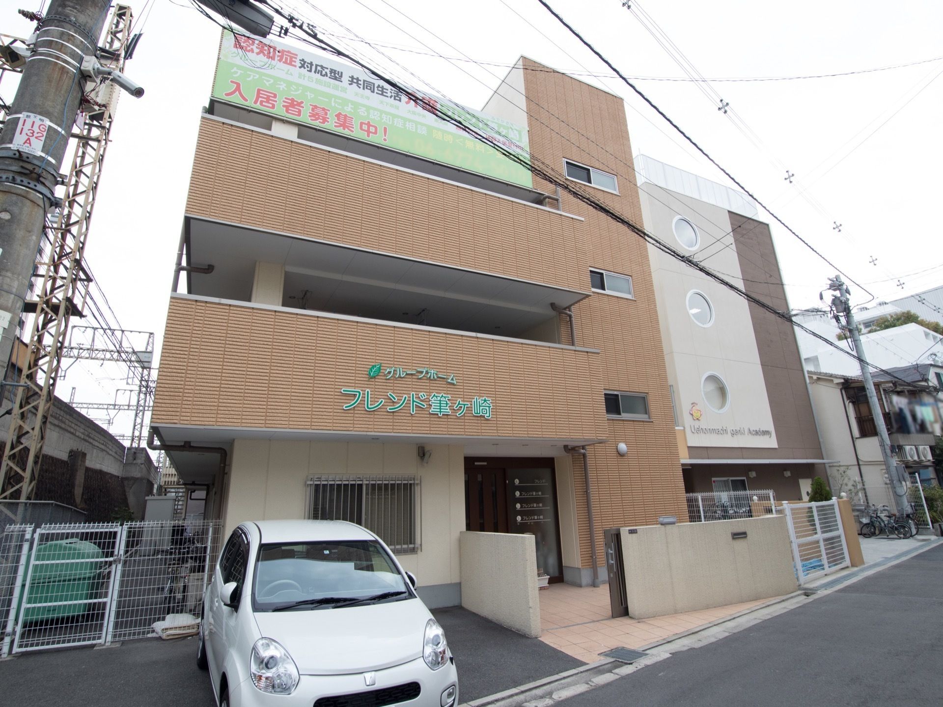 当施設は地上４階建てに地下一階がついた構造となっている。認知症対応の旨が入居者様募集の横断幕に書かれている。