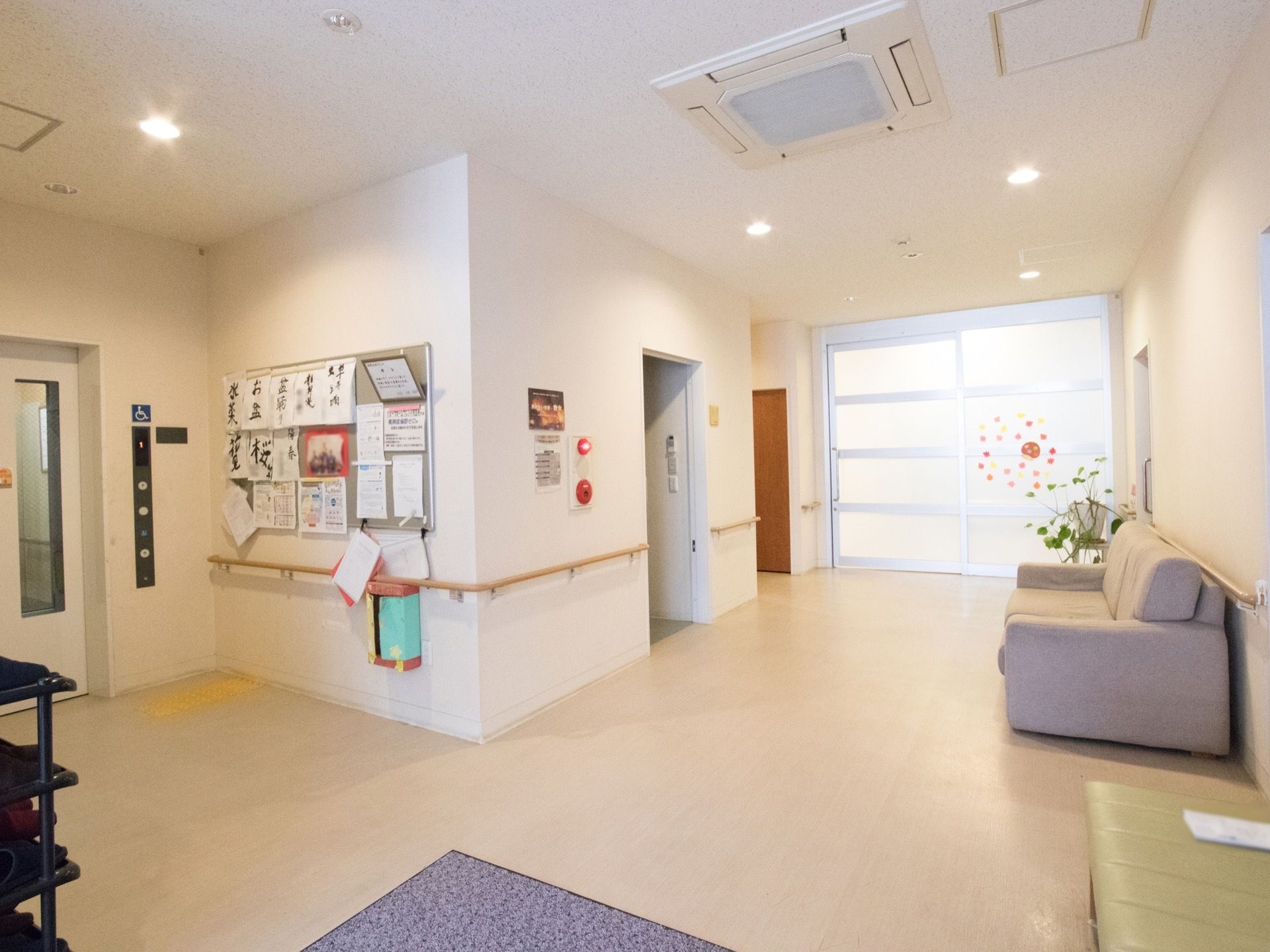 玄関から入ってすぐにあるエントランスホール。エレベーターの横の掲示板には入居者様の作品などが展示してある。