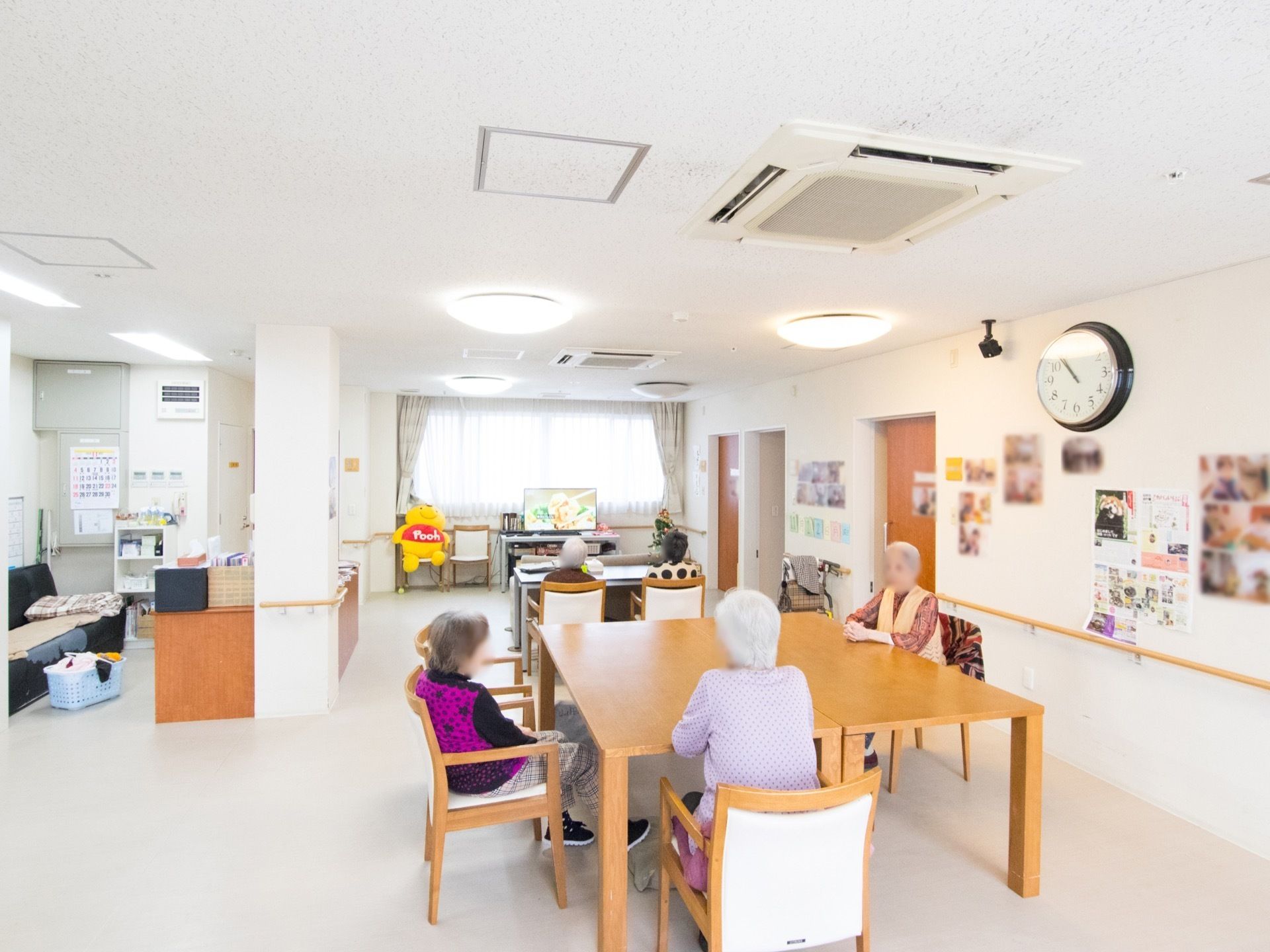 リビングと食堂を兼ねた共有スペース。窓際には大きなテレビがある。写真左側には施設スタッフ用の事務スペースが設けてある。