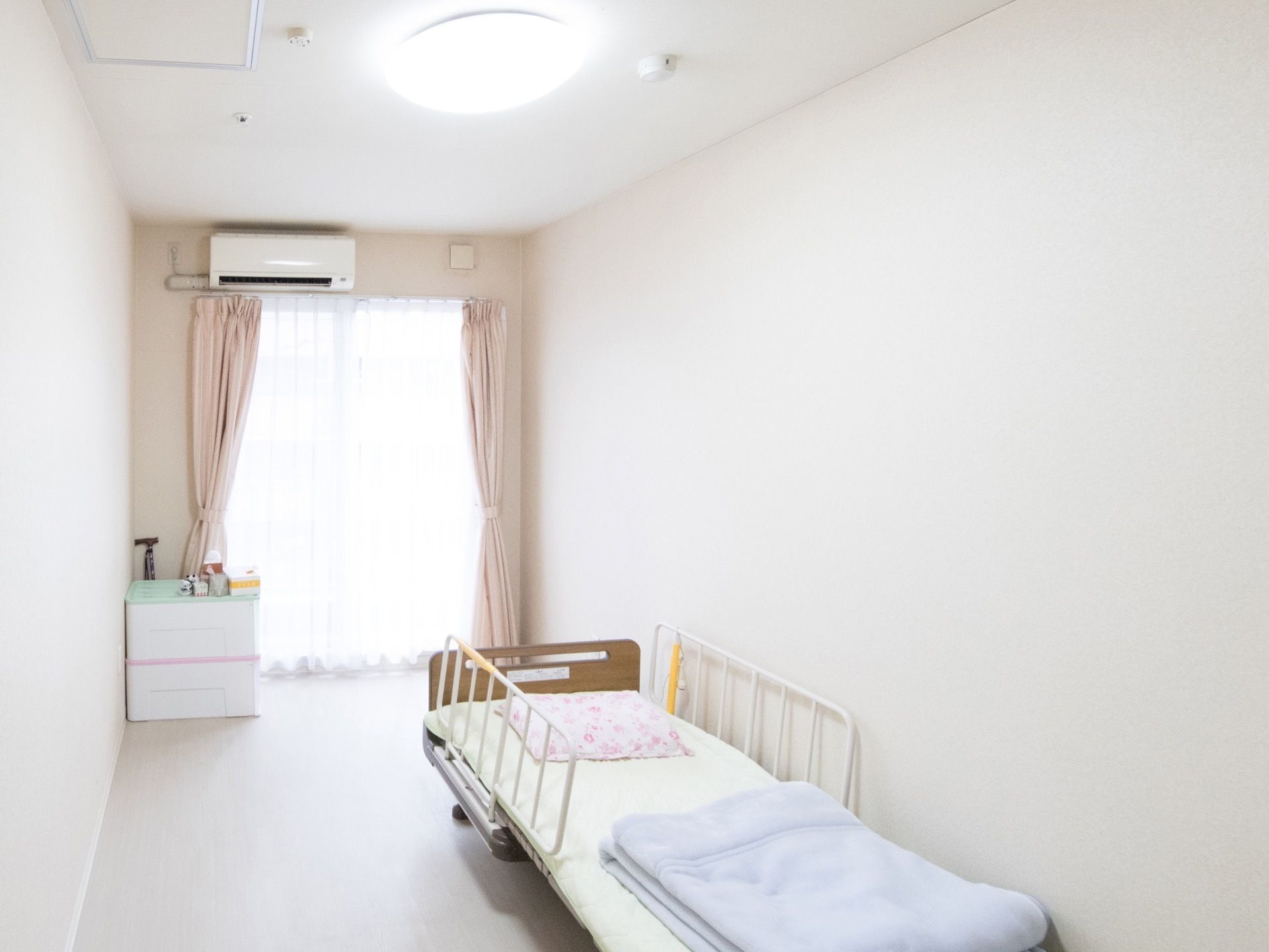居室は細長いシンプルな構造をしている。窓からは通路を兼ねたバルコニーに出られ、その上にはエアコンが設置されている。