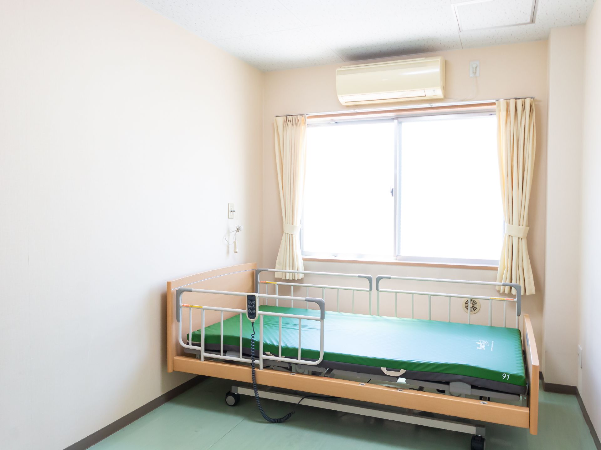 柵の設置された大きなベッドのある居室