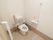 白で統一された清潔感のあるトイレである。温水洗浄便座なのでボタン1つで操作ができ便利である。手すりも完備されている。