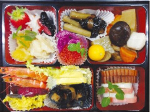 伊達巻やかまぼこ、昆布巻きなどが盛りつけられたおせち料理