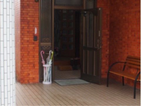玄関前には、傘立てを置き、雨の日に外で傘を用意できるようにしている。ベンチを置き、座って車が待てる場所を作っている。