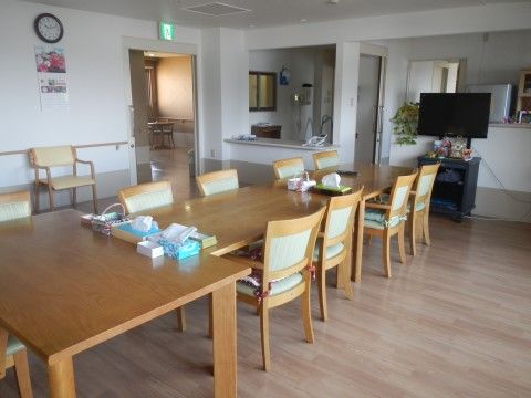 横の窓から明るい光が部屋の奥まで届き、憩える場所である。中央にはテーブルセットを並べテレビもあり、横開きのドアの上には誘導灯がある。