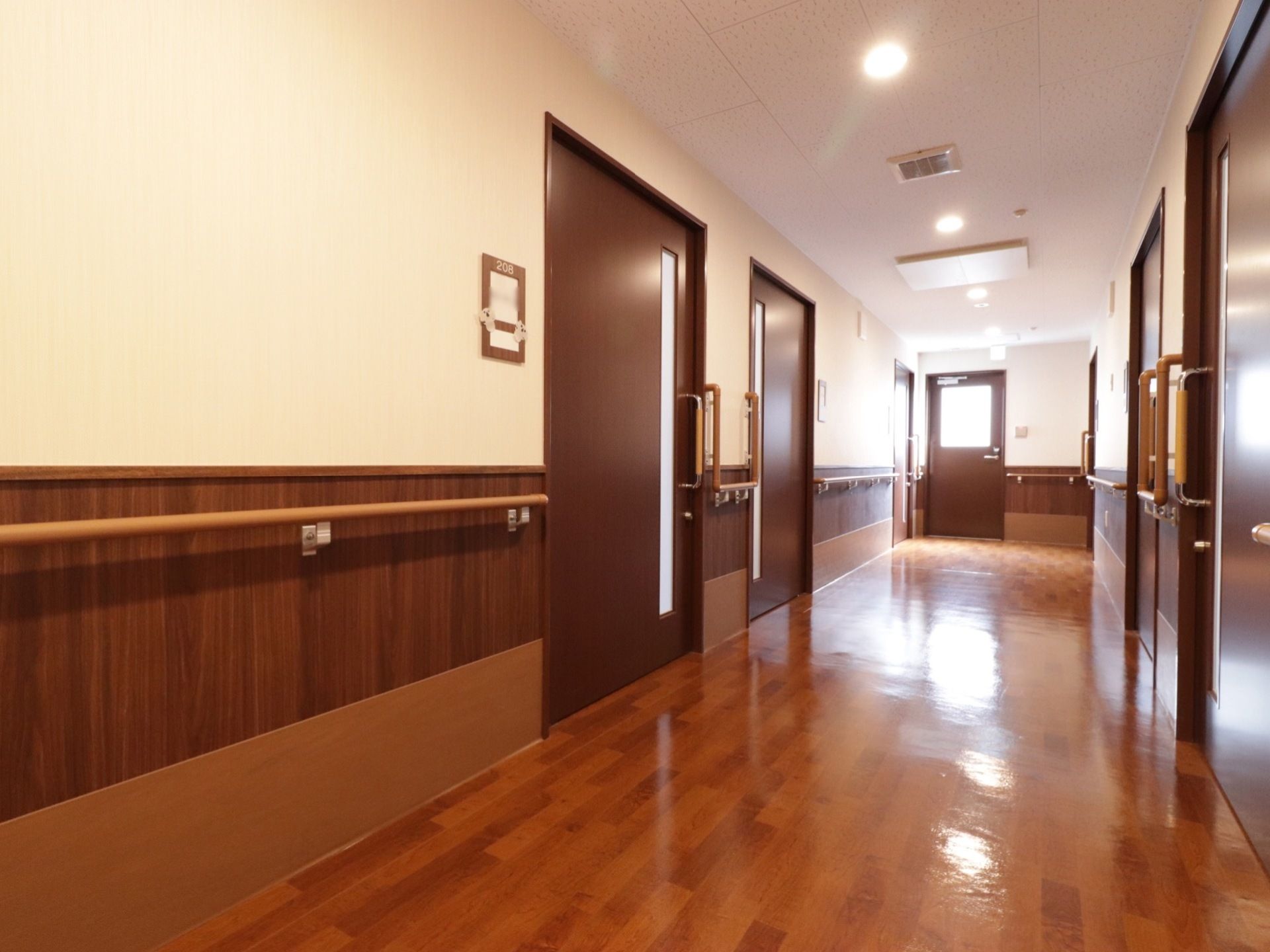 壁には全て手すりがついている。照明が明るく、部屋数も多いが廊下の幅が広くて開放感がある。扉は全て横スライド式のものを使っている。