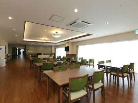 黄緑色の背もたれのついた椅子が多く並んでおり、みんなで楽しく食事をとることができるスペースとなっている。