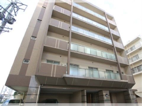 ベージュと茶色に塗り分けられた外観の６階建てのビル
