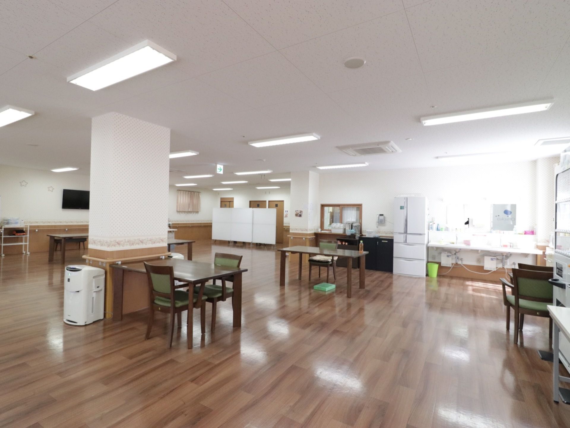 自動販売機があり、奥には洗面所が設置してある。冷蔵庫が置いてあり、隣には簡易キッチンがある。白いボードを衝立にしている。