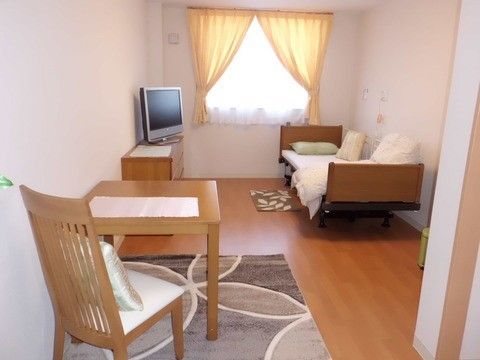 昇降機能のついた介護用ベッドが置かれている１人部屋