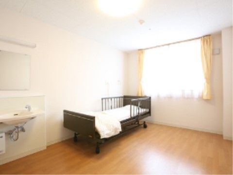 ゆったりとしたスペースを設けた居室である。車椅子をご利用の方でも使用しやすい、足元のあたらないデザインのシンプルな洗面台を備えている。