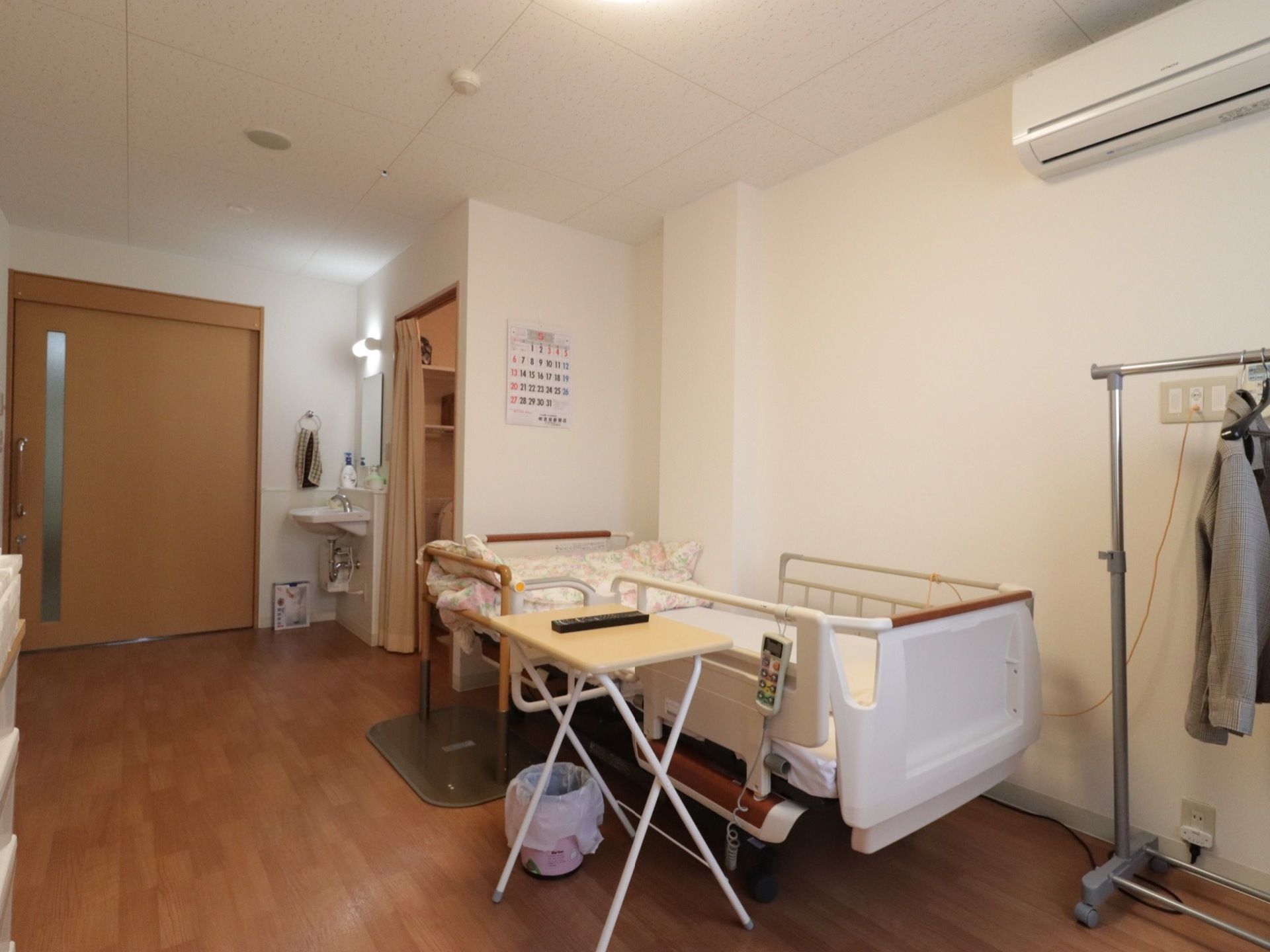 居室は車椅子をご利用の方でも余裕をもって生活できる広さである。エアコンや洗面台など、必要な生活器具がそろっている。
