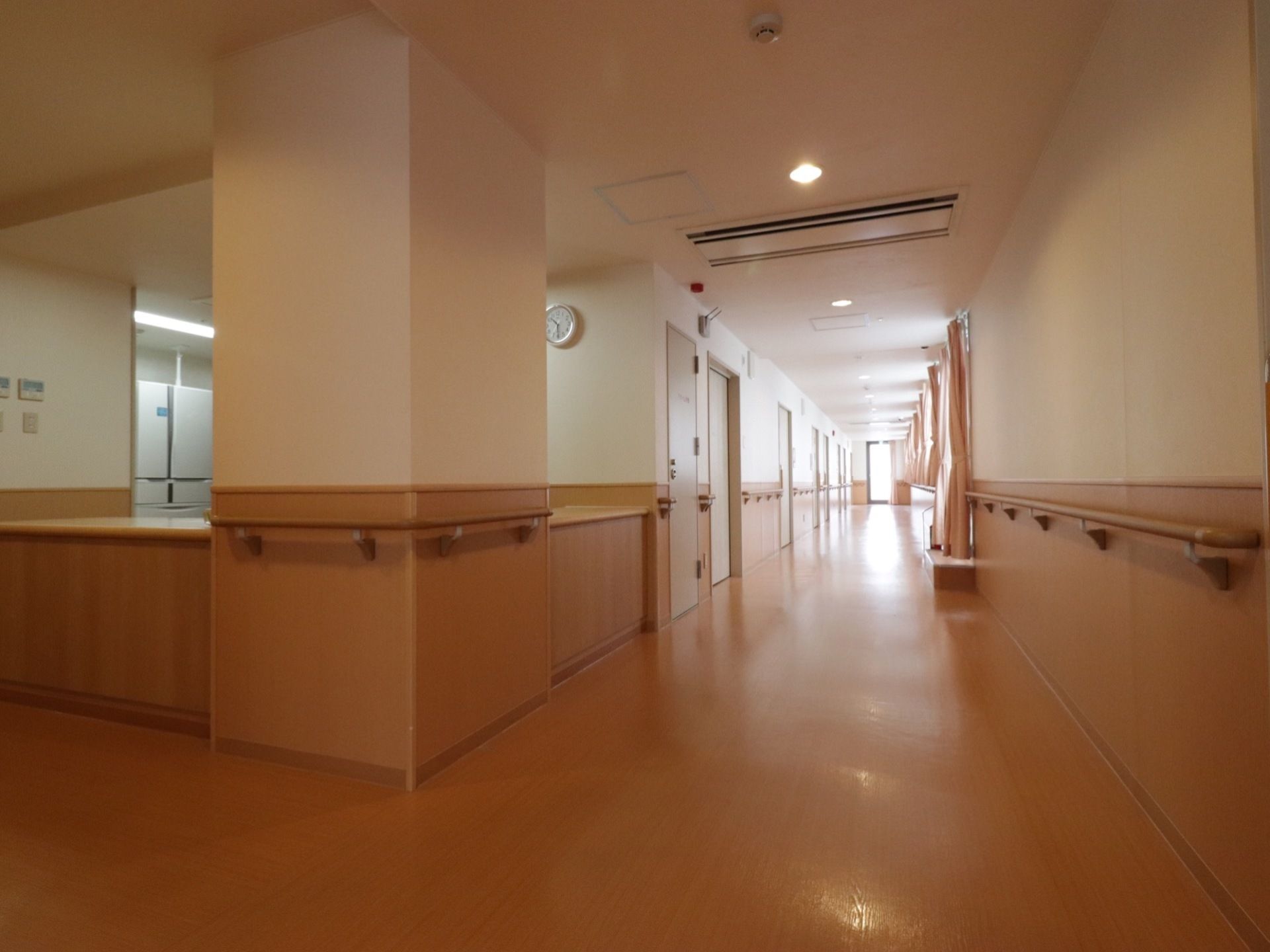 大きな柱には手すりが取り付けられている。まっすぐに続く通路にも手すりがあり、右側には長いカーテンがかけられている。