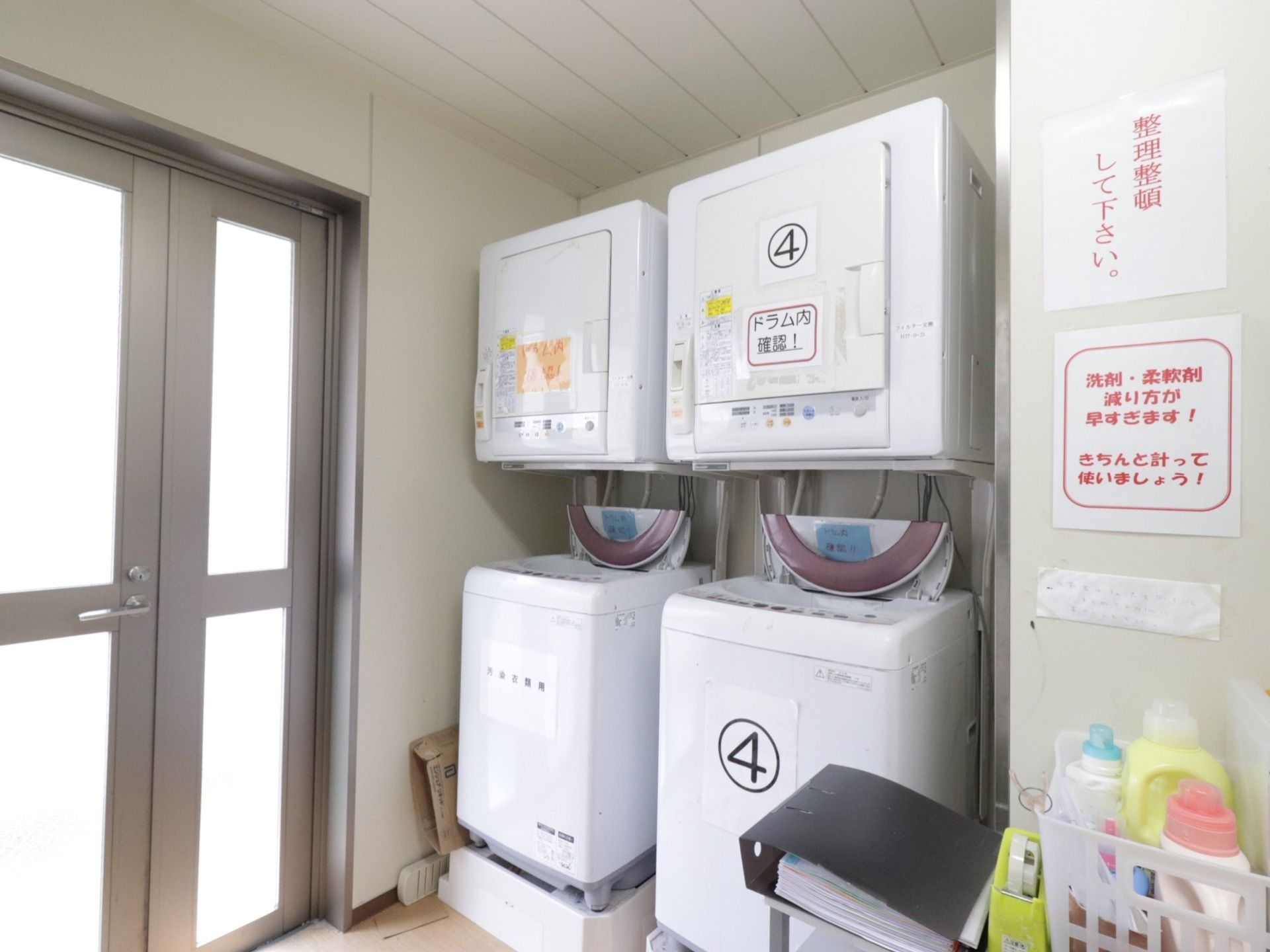 ランドリールームには洗濯機2台の上に、乾燥機2台が設置されている。片側の洗濯機と乾燥機には大きく数字の4が書かれた紙が貼られている。