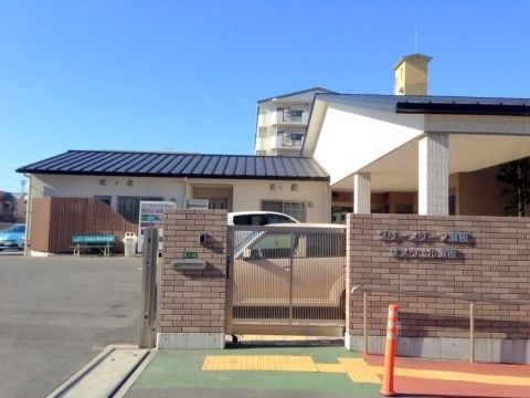 地面が赤と緑に塗られたスロープが続いている入口前の外観