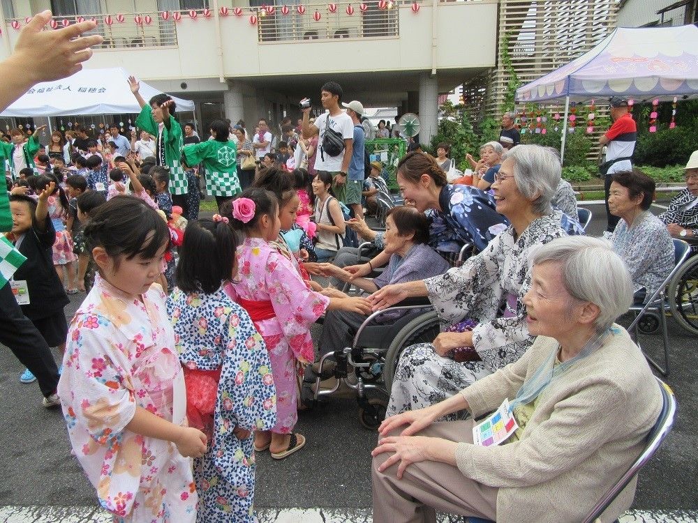 近所の夏祭りに参加して、浴衣姿の子供たちと交流する入居者様