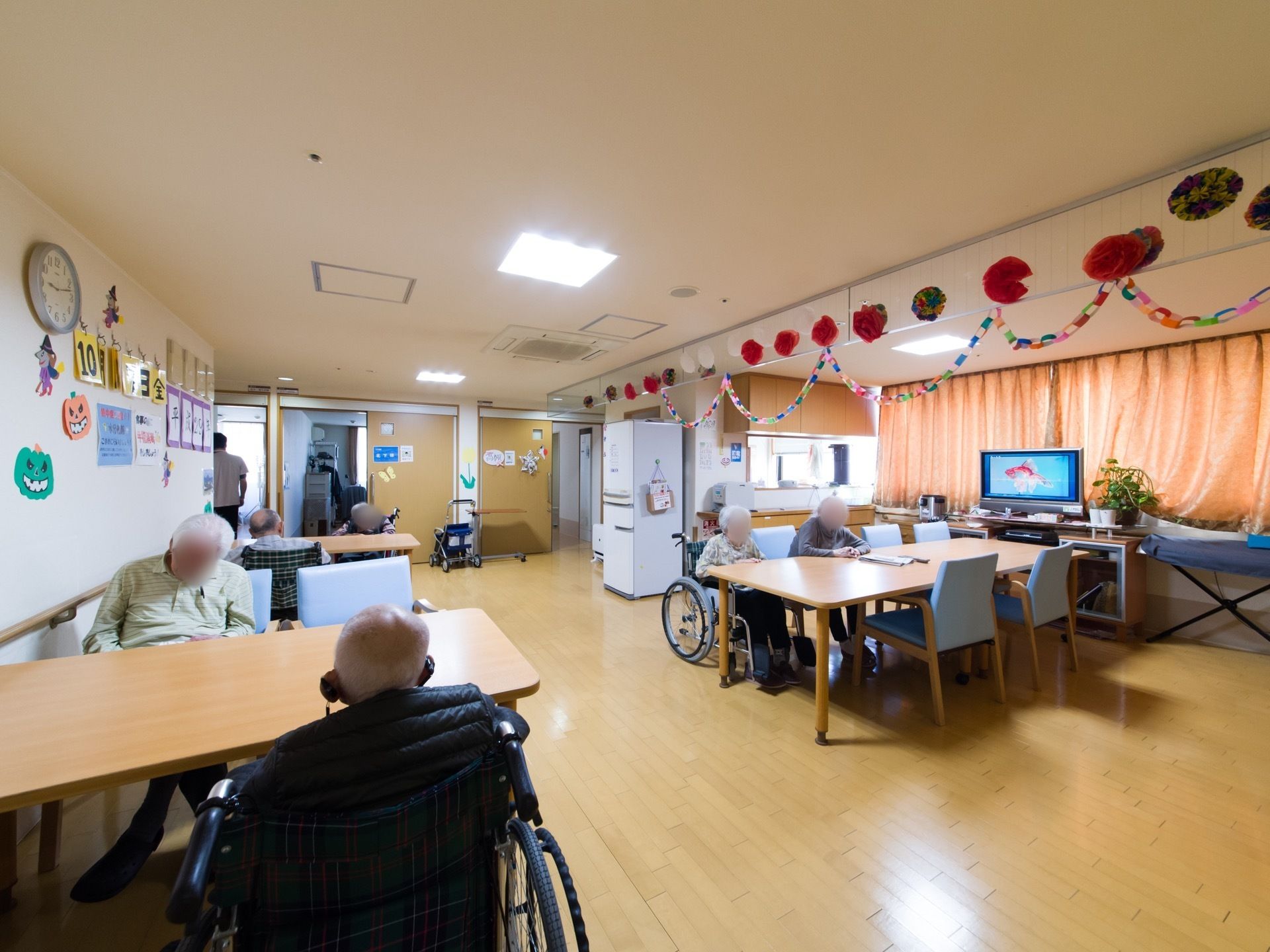 談話コーナー、食堂として使う部屋のテーブルは車椅子をご利用の方も広々使える。テレビを見たりお話しして過ごすことができる。