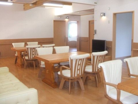 白い椅子が４脚ずつ置かれたテーブルが並ぶダイニング