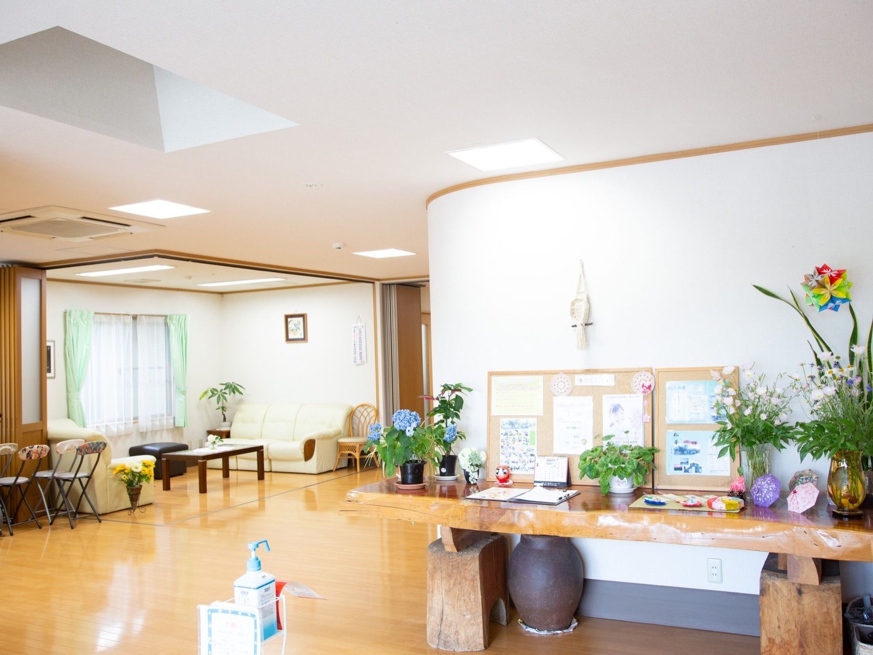 エントランスには木製の厚い板を設置した上に、花やさまざまな作品が飾られている。奥の談話スペースは、レール式仕切り扉で個室になる。