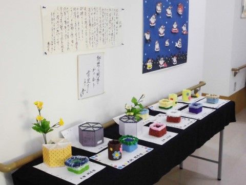 黒い布がかけられたテーブルに、入居者様が製作した作品が飾られた廊下