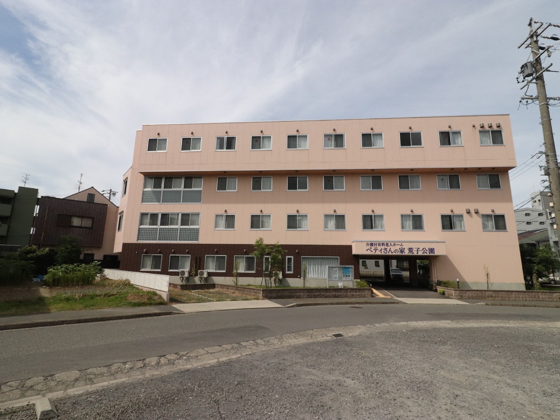 マンションのような建物となっている施設の手前には、ロータリーのような広場があり、自動車が通れるような道路となっている。