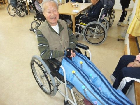 車椅子に座って、ぴんと足を伸ばして笑っている男性入居者様