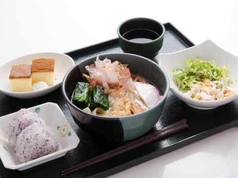 しそごはんのおにぎりやサラダが添えられた、うどんがメインの食事