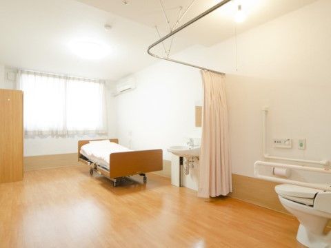 居室には、ドアを取り除いたトイレを設けている。カーテンで仕切っているので出入りが楽である。エアコン、洗面台も備えている。