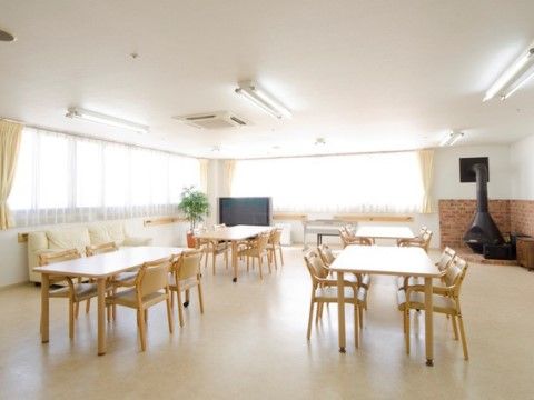 広々としたスペースに十分な間隔を置いて、テーブルセットを配置している。正面と横側にガラス張りが広がり明るい空間である。