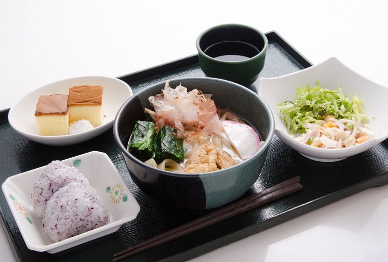 おにぎりとうどんと、カステラのデザートが付いたメニュー