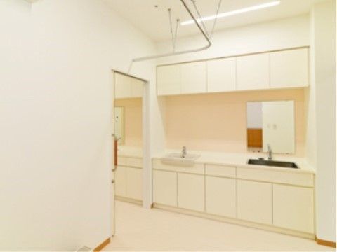 白を基調とした診療室には、洗面台や鏡が設置されている。室内のドアはスライド式となっており、車椅子でも簡単に出入りできる。