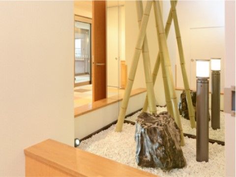 中庭には白石を敷き詰め、竹や石のオブジェを置いている。和風テイストで落ち着いた安らぎの空間となっている。