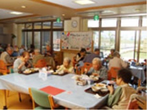 テーブルを囲んで食事を楽しむ高齢者