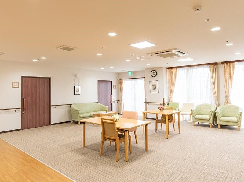 散髪台に座ってスタッフに髪を切ってもらっている入居者様