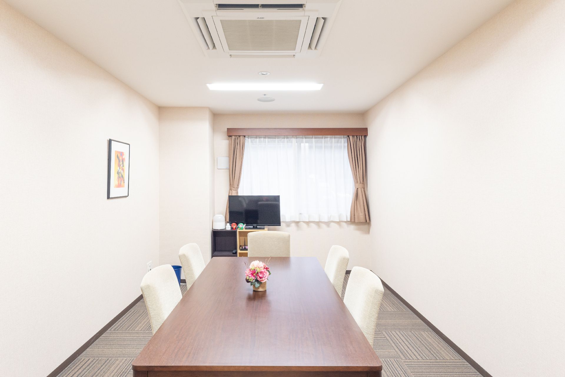 広くてゆったりとした高級感のある部屋。座り心地の良いソファと大型液晶テレビ、空気清浄機が完備されている。