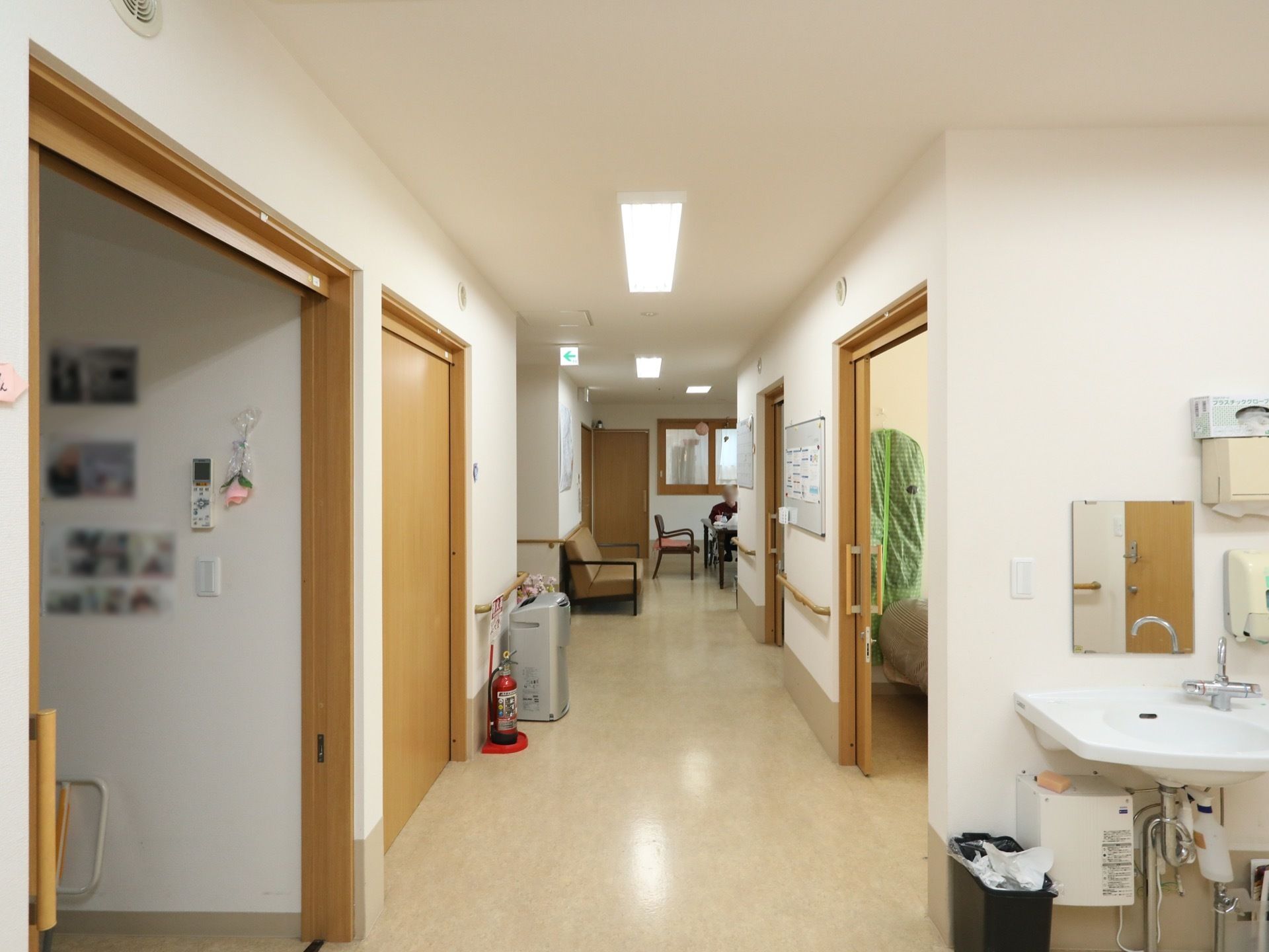 白が基調の明るい通路である。外出から戻ったらすくに手洗いうがいができるように、洗面台が完備されている。
