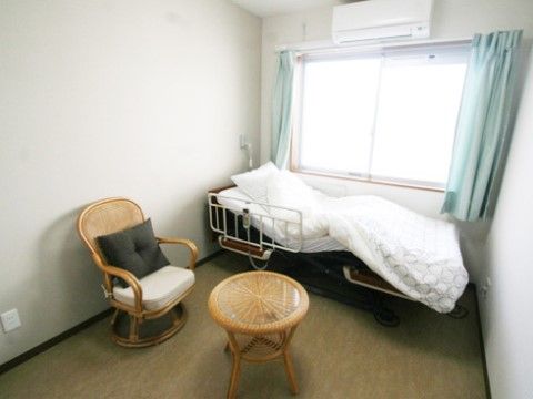白色を基調とした居室である。腰窓があり、窓に沿ってシングルサイズのベッドが置かれている。エアコンが完備されている。