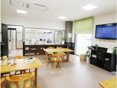 右手の壁に大型液晶テレビが設置されている共有スペース