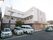 ３階建てのＬ字型の建物で、白と茶色に塗られている。建物の前に施設で所有するワゴンや、軽乗用車が停められている。