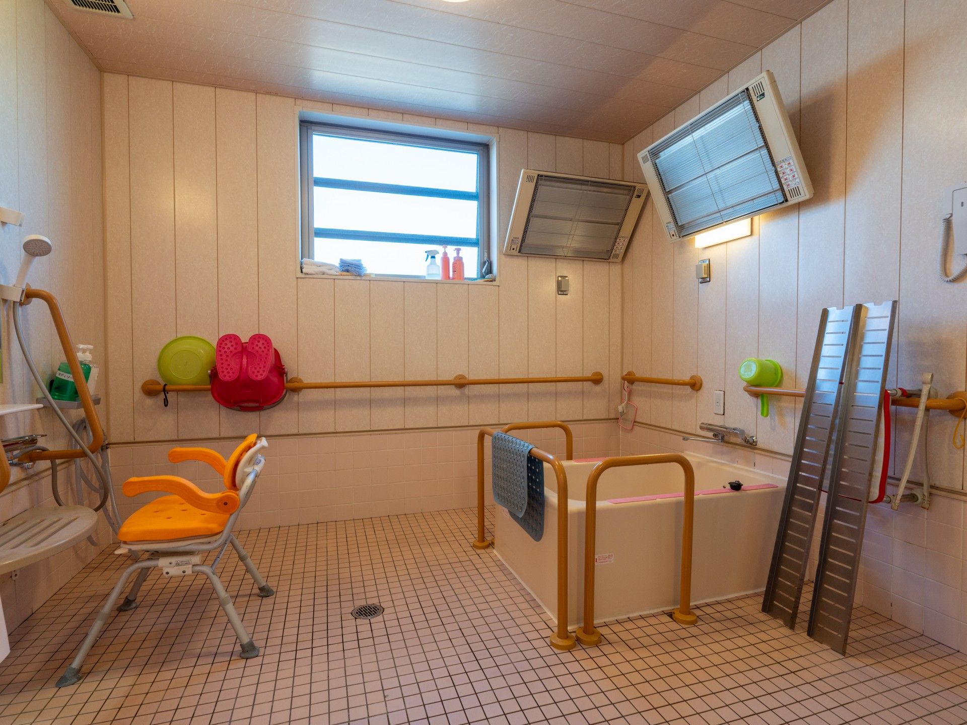 介護車両の前にいる車椅子に座っている高齢女性と介助をする女性ヘルパー