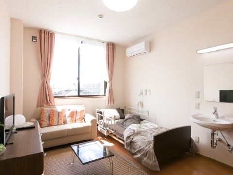 窓から日差しの入り込み、家具が取り揃えられた生活部屋