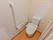 居室のトイレはカーテンで仕切られており、出入りがスムーズになっている。壁には手すり、洗浄機能付き便座、緊急時ボタンもある。
