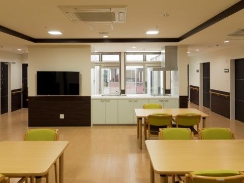 奥に照明が点いたスタッフの事務所があるダイニングルーム