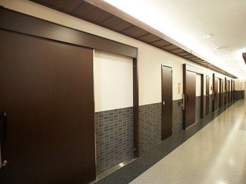 大きく開く引き戸の居室入口のドアが等間隔に並ぶ廊下