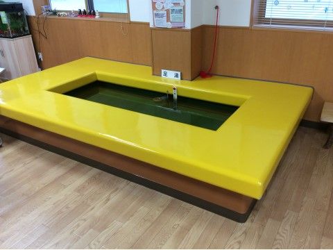 黄色いクッションマットで口の字に囲まれている共同足湯