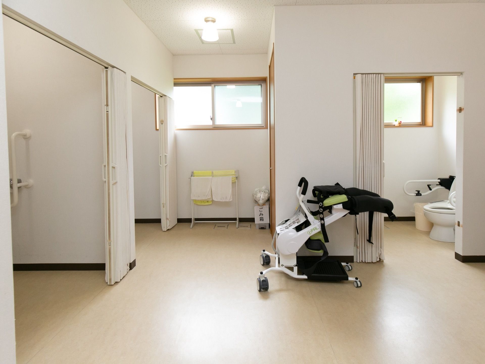 ジャバラ式のカーテンで仕切ることができるトイレである。便器の両側には、可動式の手すりが設置されている。
