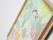 黄色とピンクの額縁に入れられた、女の子が描かれた水彩画