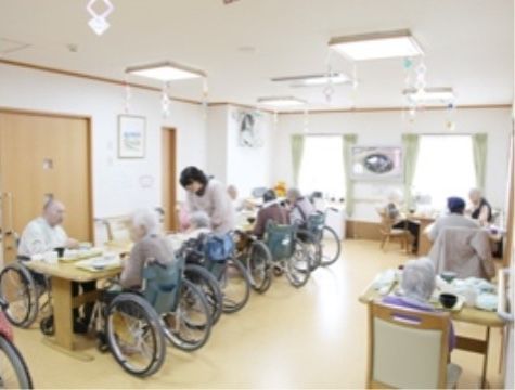 車椅子に乗ってダイニングのテーブルに集まっている入居者様